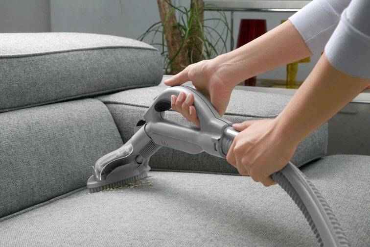 Using a vacuum to clean a sofa